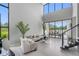 Bright and airy living room with soaring ceilings, modern furnishings, and large windows offering scenic outdoor views at 7602 Antilla St, Tampa, FL 33625