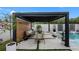 A shaded pergola features poolside seating with a view of the pool and landscaped backyard at 7602 Antilla St, Tampa, FL 33625