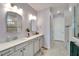 Double sink bathroom with modern gray tile and updated lighting at 8705 Coastal Key Way, Parrish, FL 34219
