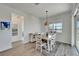 Bright dining room features a light wooden table with four chairs, and a stylish light fixture at 8705 Coastal Key Way, Parrish, FL 34219