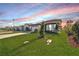Single-story house with a grassy yard and paved driveway at sunset at 8705 Coastal Key Way, Parrish, FL 34219