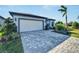 Single-story house with a white garage door and landscaped front at 8705 Coastal Key Way, Parrish, FL 34219
