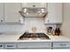 Modern kitchen with gas cooktop and stainless steel range hood at 8705 Coastal Key Way, Parrish, FL 34219