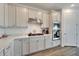 Modern kitchen with white cabinets, stainless steel appliances and gas cooktop at 8705 Coastal Key Way, Parrish, FL 34219