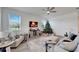 Cozy living room includes a comfy sectional sofa, a Christmas tree, and a large TV at 8705 Coastal Key Way, Parrish, FL 34219