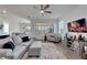 Open living room with a sectional sofa, large TV and ceiling fan at 8705 Coastal Key Way, Parrish, FL 34219