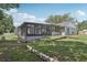 The beautiful backyard has a retaining wall, a screened-in pool enclosure, and a large grassy area at 1009 Black Knight Dr, Valrico, FL 33594