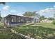 The beautiful backyard has a retaining wall, a screened-in pool enclosure, and a large grassy area at 1009 Black Knight Dr, Valrico, FL 33594