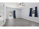 Bedroom with a ceiling fan, gray vinyl plank flooring, and a sliding door that leads to a pool at 1009 Black Knight Dr, Valrico, FL 33594