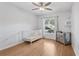 Cozy Bedroom with a white crib, playpen, wood flooring and light-colored walls at 1009 Black Knight Dr, Valrico, FL 33594