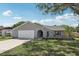 Charming single-story home features a manicured lawn, a gray exterior, and a two-car garage at 1009 Black Knight Dr, Valrico, FL 33594