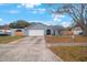 Gray house with white garage door, arched entryway, and landscaped yard at 1009 Black Knight Dr, Valrico, FL 33594