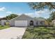 Charming single-story home features a manicured lawn, a gray exterior, and a two-car garage at 1009 Black Knight Dr, Valrico, FL 33594