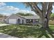 Charming single-story home with manicured lawn, flower beds, and a beautiful mature tree at 1009 Black Knight Dr, Valrico, FL 33594