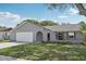 Charming single-story home features a manicured lawn, a gray exterior, and a two-car garage at 1009 Black Knight Dr, Valrico, FL 33594