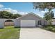 View of the home featuring a two-car garage, front yard, and neutral gray exterior at 1009 Black Knight Dr, Valrico, FL 33594