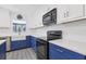 Modern kitchen with white cabinets, blue lower cabinets, and stainless steel appliances at 1009 Black Knight Dr, Valrico, FL 33594