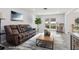 Bright living room with modern furnishings, a leather couch, a rug, and natural light at 1009 Black Knight Dr, Valrico, FL 33594