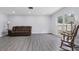 Spacious living room featuring gray flooring, a brown sofa, and bright natural light at 1009 Black Knight Dr, Valrico, FL 33594