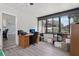 Bright sunroom with natural light, windows, laminate floors and an office area at 1009 Black Knight Dr, Valrico, FL 33594