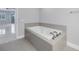 White bathtub with gray tile surround in a contemporary bathroom at 12077 Gandy N Blvd # 332, St Petersburg, FL 33702