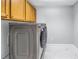 Laundry room with modern washer and dryer, overhead storage cabinets and tile flooring at 12077 Gandy N Blvd # 332, St Petersburg, FL 33702