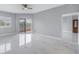 Spacious living room features modern ceiling fan, glossy tile floors, and balcony access at 12077 Gandy N Blvd # 332, St Petersburg, FL 33702