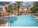 Community pool with clubhouse, lounge seating, and landscaping, set against a condo building backdrop at 12077 Gandy N Blvd # 332, St Petersburg, FL 33702
