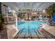 Community pool framed by a modern pergola, palm trees, landscaping, and condo buildings at 12077 Gandy N Blvd # 332, St Petersburg, FL 33702