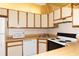 Galley kitchen with ample cabinetry, built-in microwave and range at 12119 Sunny Glen Ln # F1, Hudson, FL 34669