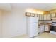 Efficient kitchen featuring white appliances and wood cabinets at 12119 Sunny Glen Ln # F1, Hudson, FL 34669