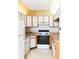 Galley-style kitchen with wood cabinets and appliances at 12119 Sunny Glen Ln # F1, Hudson, FL 34669