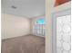A bright living room features carpeted floors, shuttered windows and a glimpse of the glass paned front door at 1406 Deerbourne Dr, Wesley Chapel, FL 33543