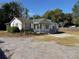 Single story home with green roof, stone facade, and a large yard at 16118 Hanna Rd, Lutz, FL 33549