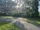 Green house with boarded windows and palm trees at 17104 Rainbow Ter, Odessa, FL 33556