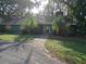 Green house with brick walkway and boarded windows at 17104 Rainbow Ter, Odessa, FL 33556