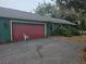 Red garage door with a white chair in front at 17104 Rainbow Ter, Odessa, FL 33556