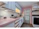 Pink countertop kitchen with white cabinets and appliances at 18675 Us Highway 19 N # 125, Clearwater, FL 33764