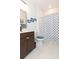 Clean bathroom with dark brown vanity, shower, and anchor-themed shower curtain at 19494 Sea Glass Cir, Land O Lakes, FL 34638