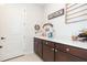 Laundry room with dark brown cabinets, utility sink, and built-in shelving at 19494 Sea Glass Cir, Land O Lakes, FL 34638