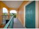 Hallway leading to condo unit with teal door and balcony access at 2733 Via Cipriani # 830A, Clearwater, FL 33764