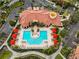 Aerial view of a community pool with red umbrellas and lounge chairs at 2733 Via Cipriani # 830A, Clearwater, FL 33764
