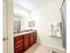 Bathroom with wood vanity, shower/tub combo, and gray accents at 30405 Elderwood Dr, Wesley Chapel, FL 33543