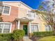 Townhome entrance with green door and manicured hedges at 30405 Elderwood Dr, Wesley Chapel, FL 33543