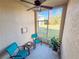 Relaxing screened porch with two teal chairs and a small table at 30405 Elderwood Dr, Wesley Chapel, FL 33543