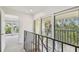 Hallway with large windows overlooking a patio and lush tropical greenery at 7550 Sunshine Skyway S Ln # T48, St Petersburg, FL 33711
