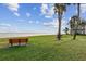 Waterfront lawn with benches, palm trees, and building at 7550 Sunshine Skyway S Ln # T48, St Petersburg, FL 33711