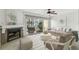 Bright living room with fireplace, neutral furniture, and sliding glass doors to a patio at 7550 Sunshine Skyway S Ln # T48, St Petersburg, FL 33711