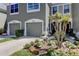 Gray townhome with two-car garage, landscaping, and a welcoming entryway at 10280 Post Harvest Dr, Riverview, FL 33578