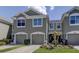Two-story townhome with gray exterior, two-car garage, and landscaped front yard at 10280 Post Harvest Dr, Riverview, FL 33578